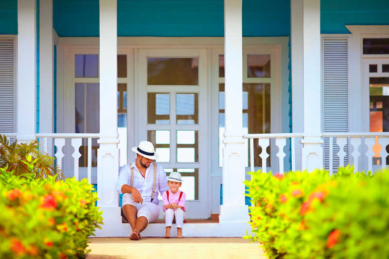 可爱的父子坐在加勒比海的门廊上