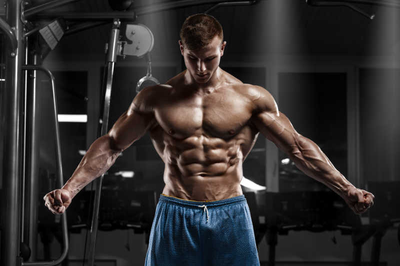 健身房里展示浑身肌肉的男人