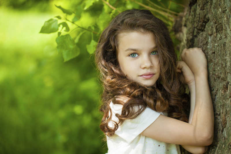 夏日公园背景下的一个漂亮小女孩的肖像