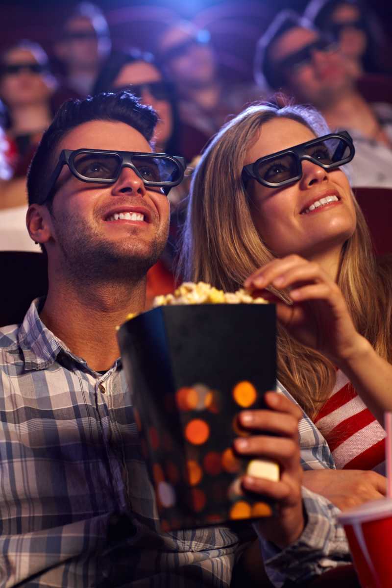 吃着爆米花看3D电影的年轻夫妇