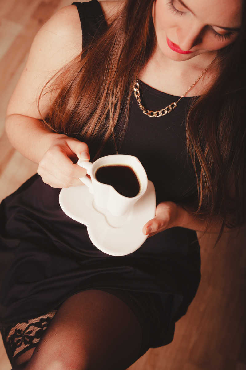 端着心形咖啡杯的黑裙美女