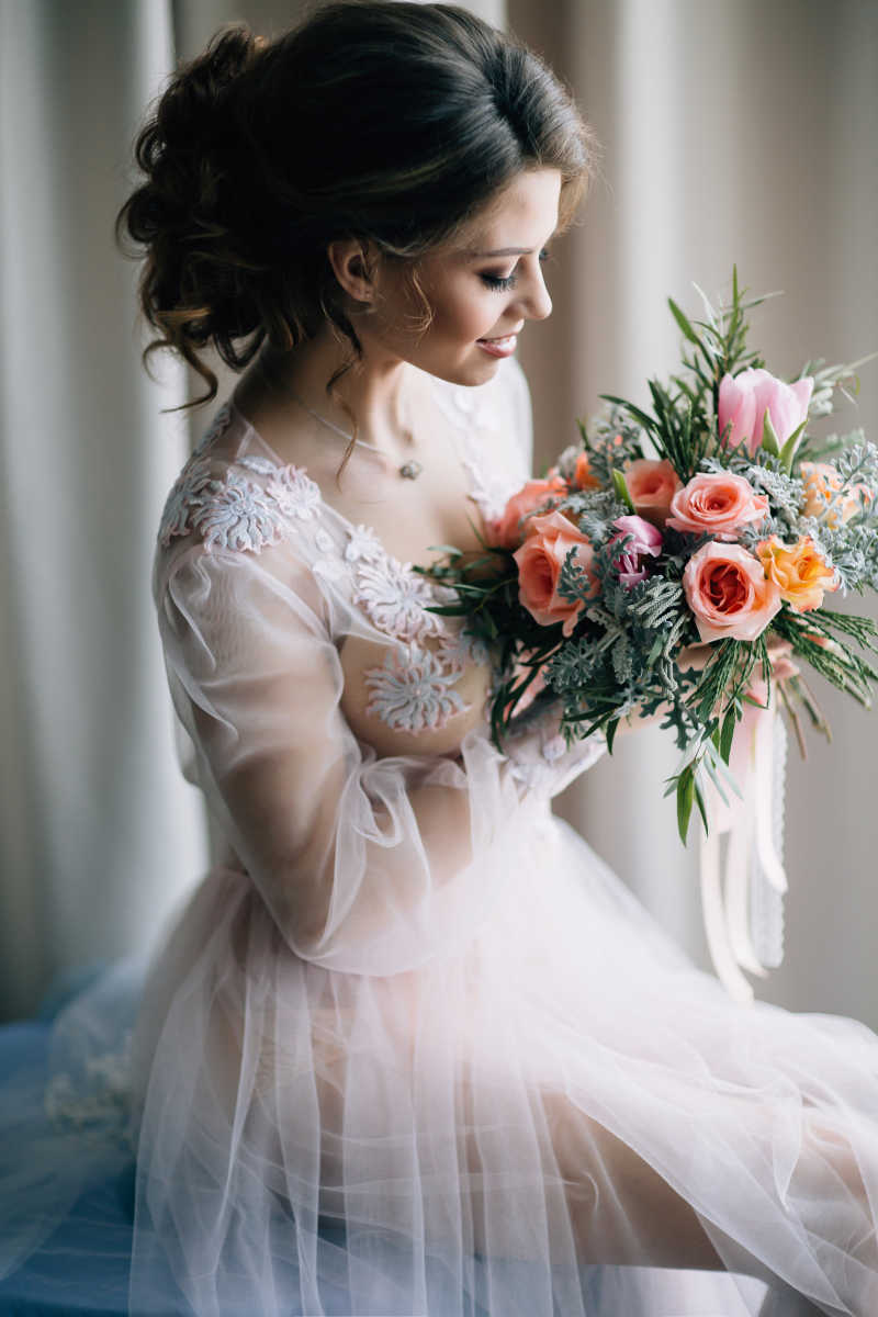 窗子旁边捧着鲜花的新娘