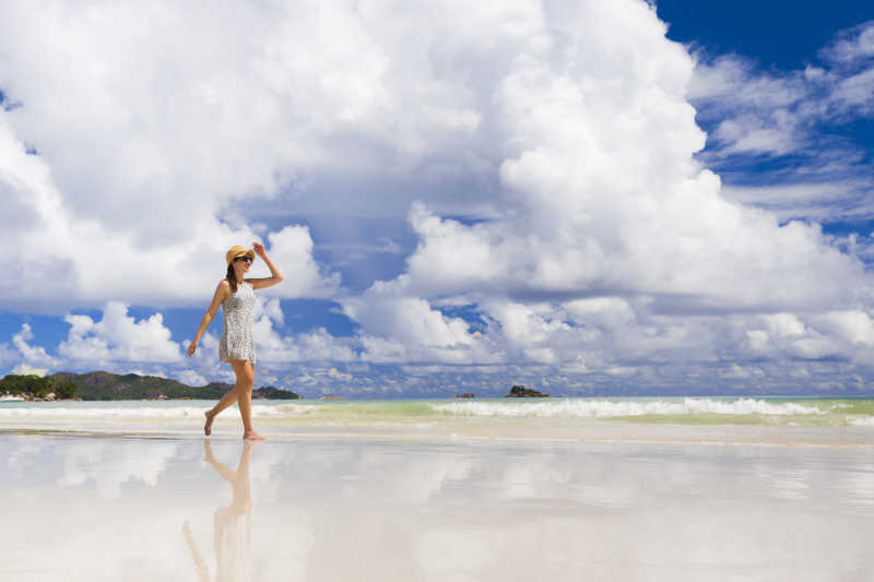 漫步在塞舌尔海滩上的美丽女人