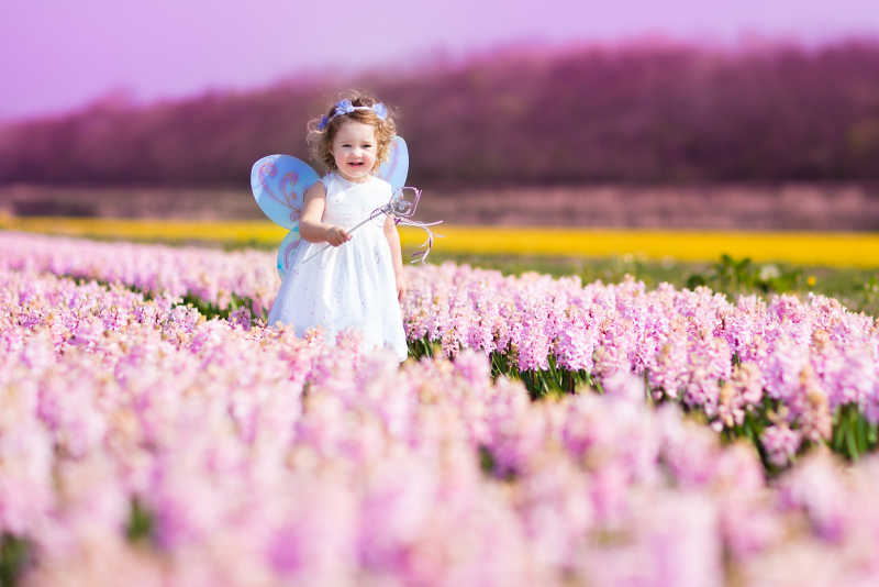在鲜花丛中跑的可爱的小女孩