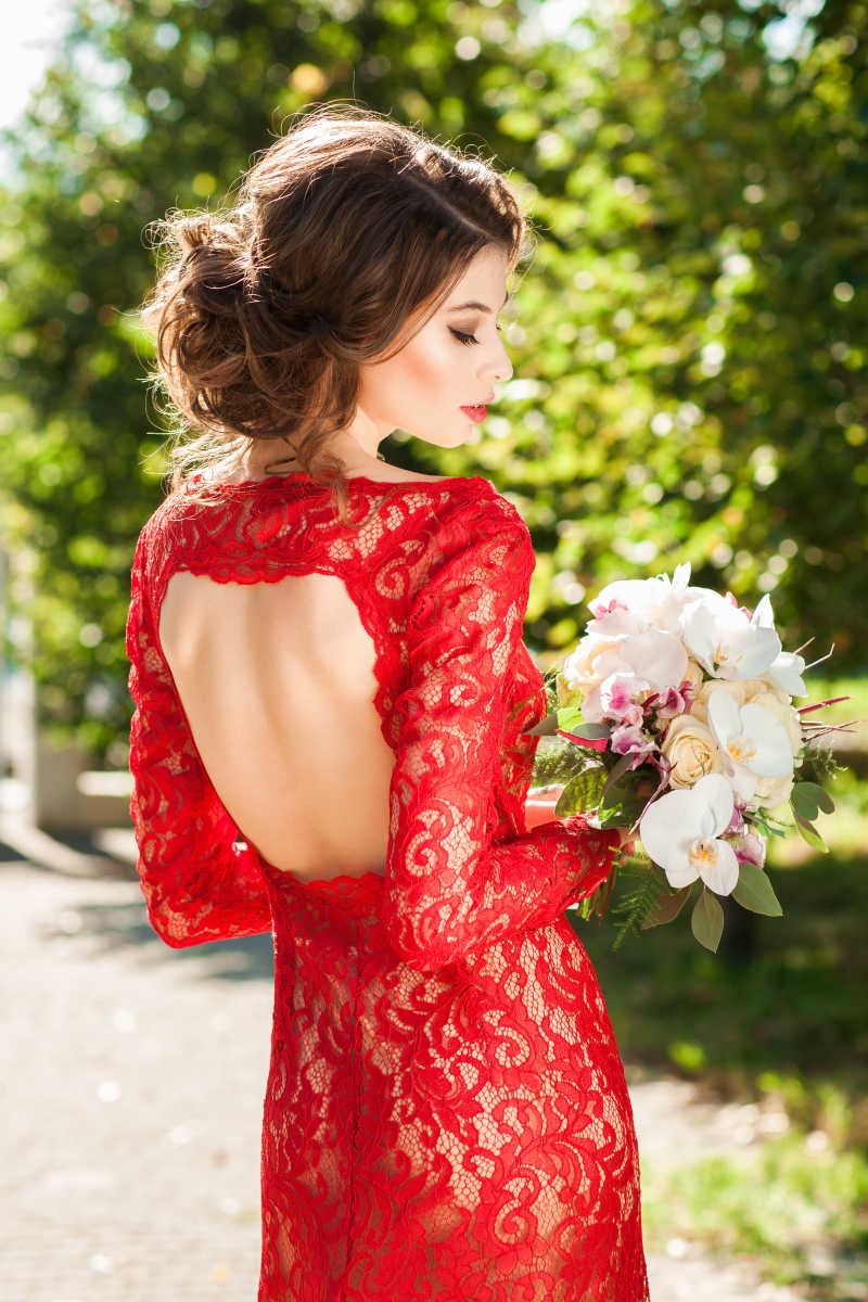 室外漂亮的穿红色蕾丝长裙的美丽女人
