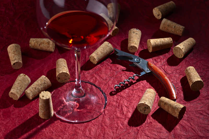 红色桌上的软木塞和红酒杯