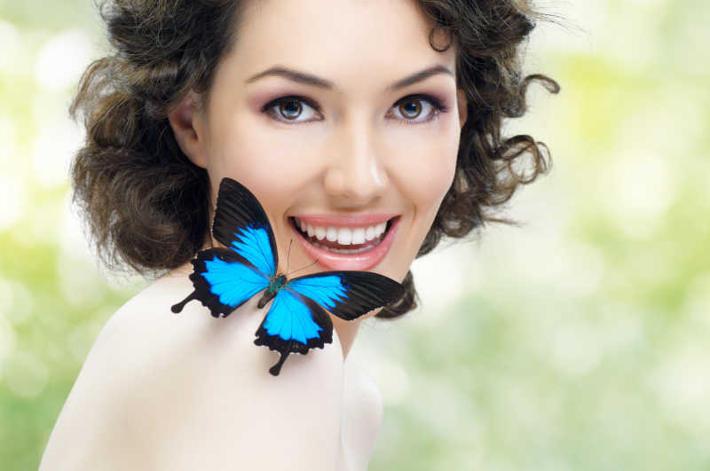 美丽女人肩上的蓝色蝴蝶