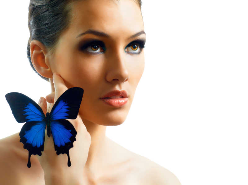 美丽的年轻女人和手上的蓝色蝴蝶