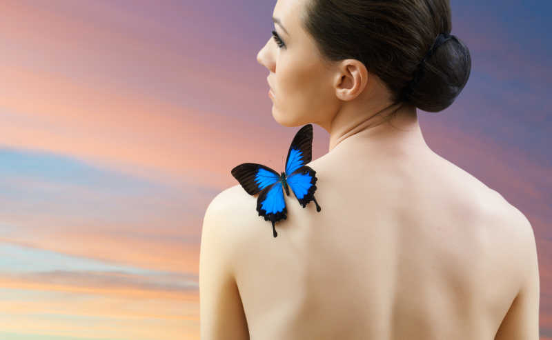 美丽女人背上的蓝色蝴蝶