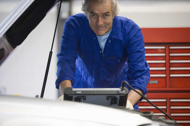 汽车修理工程师使用机械诊断与电子诊断机诊断汽车