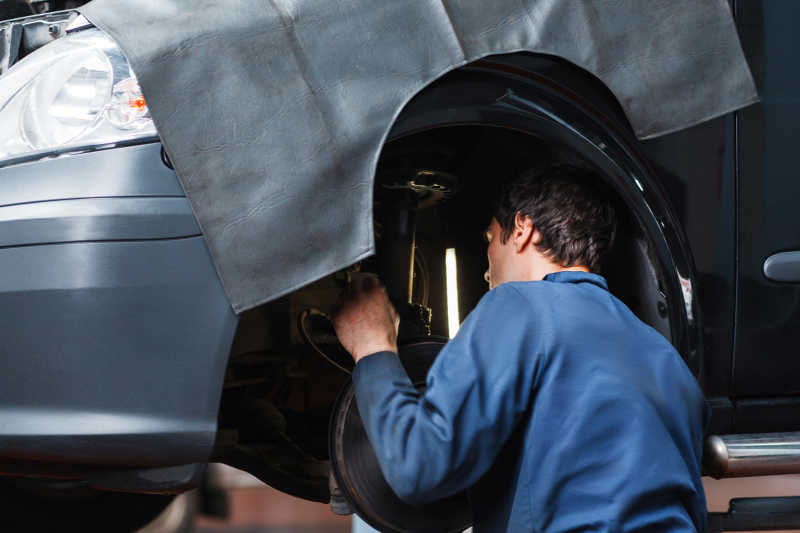 汽车维修工使用机械检测车悬架系统