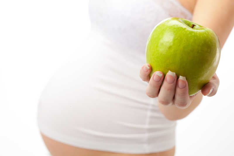 年轻健康的孕妇和新鲜苹果