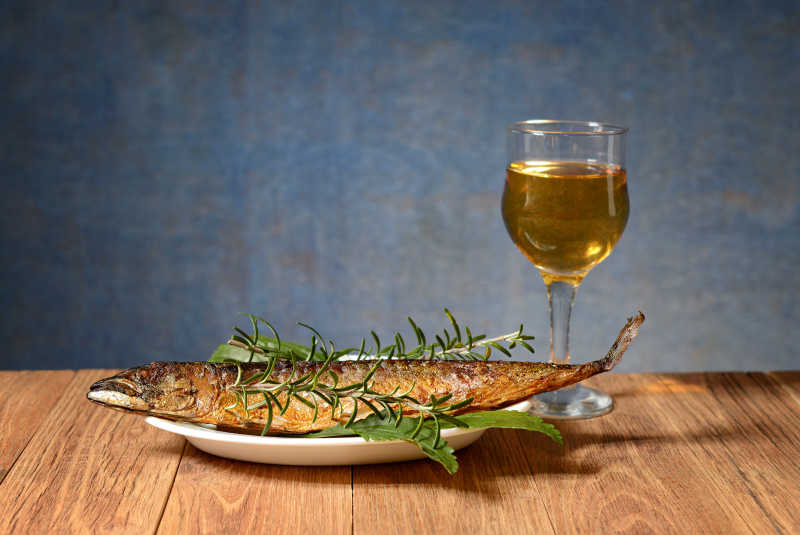 木质桌上的美味的烤鲭鱼和酒