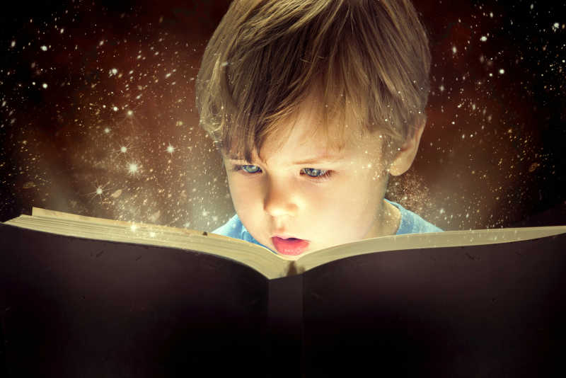  小男孩认真读着魔法书