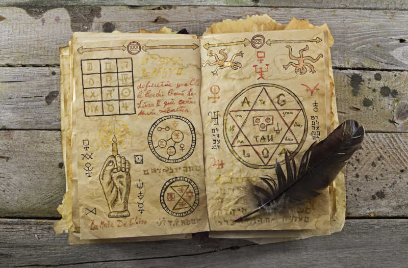 木制背景上打开的写了咒语的魔法书