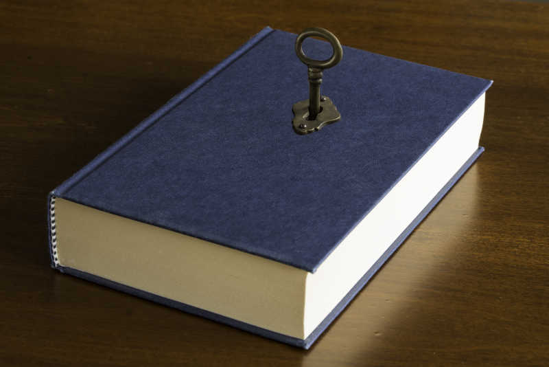 木质桌上的一本插入钥匙的魔法书