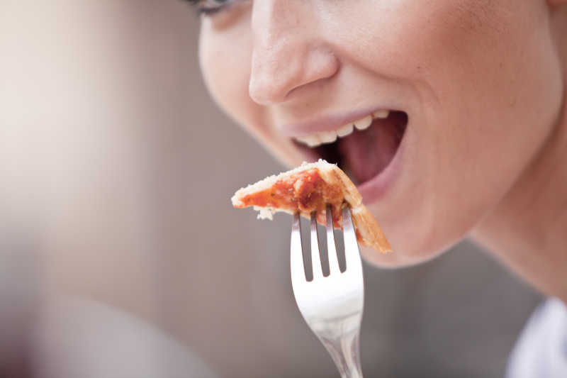 美女用叉子吃披萨