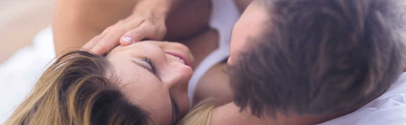 恋爱中的情侣躺在床上互相看着对方
