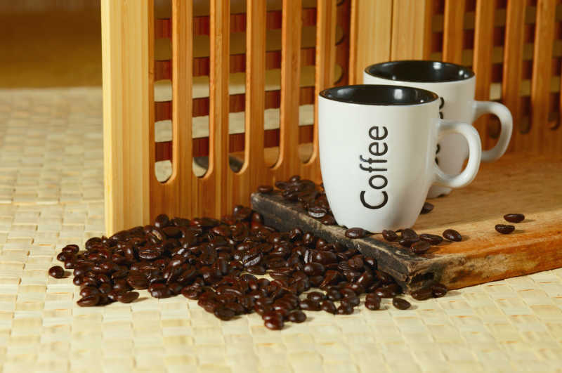 咖啡豆和木板和上的白色咖啡杯