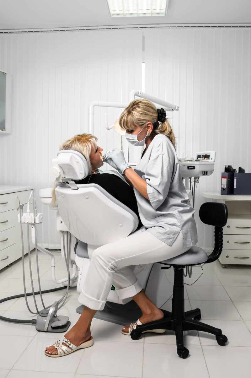 牙科女医生正在为女病人检查牙齿