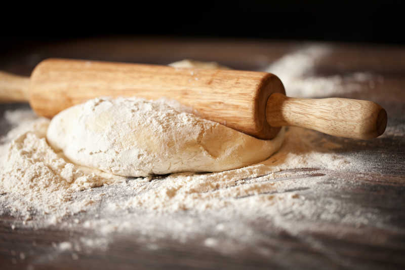 木桌上准备自作面包的面团和擀面杖