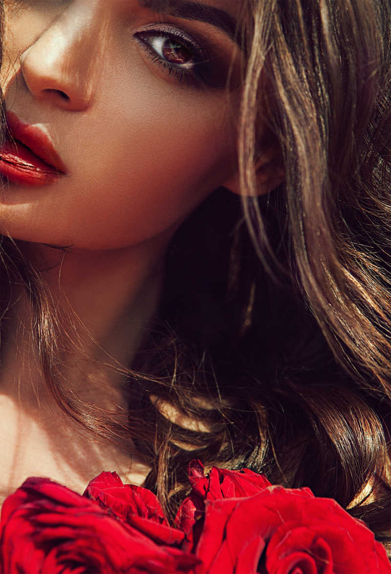 美女拿着一束红玫瑰