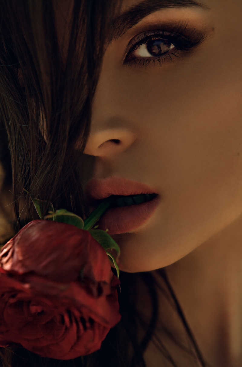 嘴里咬着玫瑰花的美女