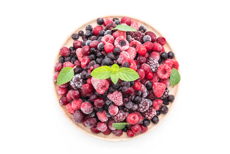 白色背景下冰冻的草莓蓝莓越桔覆盆子等多汁的水果盘俯视摄影