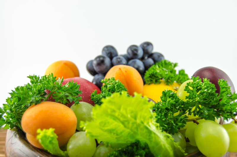 灰白色背景下新鲜的生菜杏葡萄苹果等水果和蔬菜