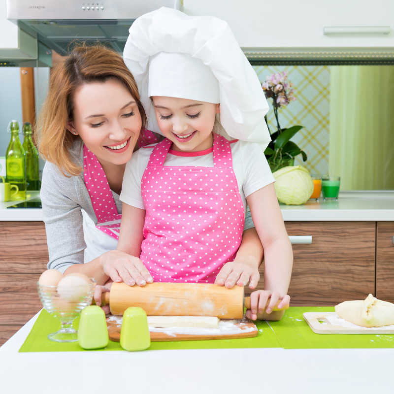 小女孩和母亲在厨房做馅饼