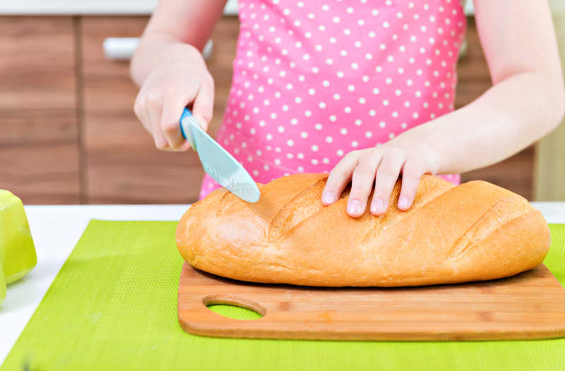 小女孩在厨房切面包