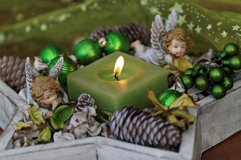 燃烧的绿色的圣诞节蜡烛和小天使