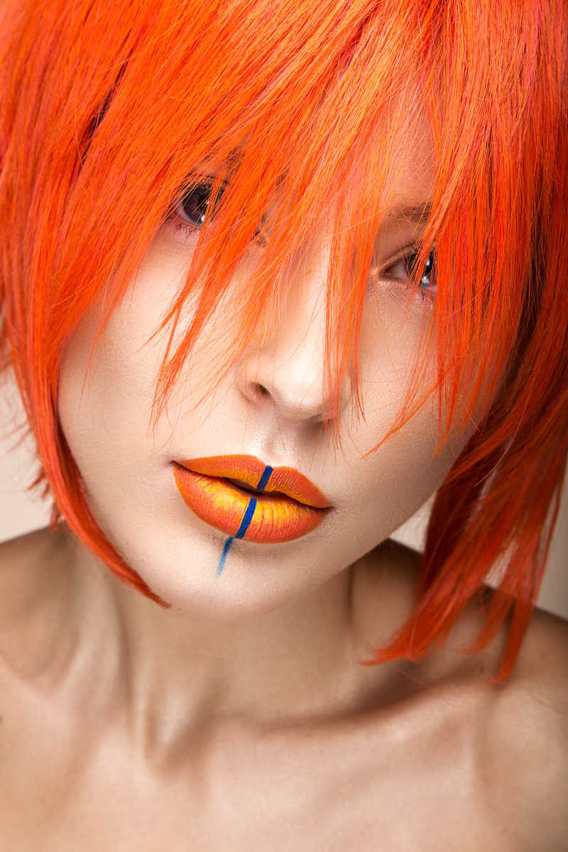 美丽的女孩在橙色假发角色扮演风格与明亮的创意嘴唇