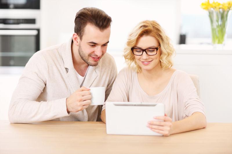 一对幸福的夫妇在家用平板电脑