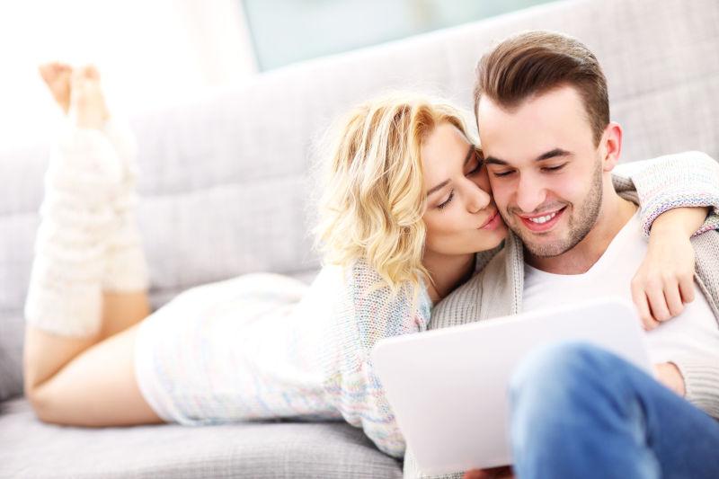 浪漫情侣在客厅里玩笔记本电脑