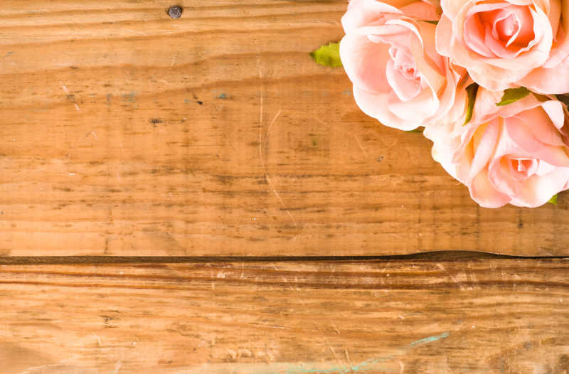 木板上放置着粉红玫瑰鲜花