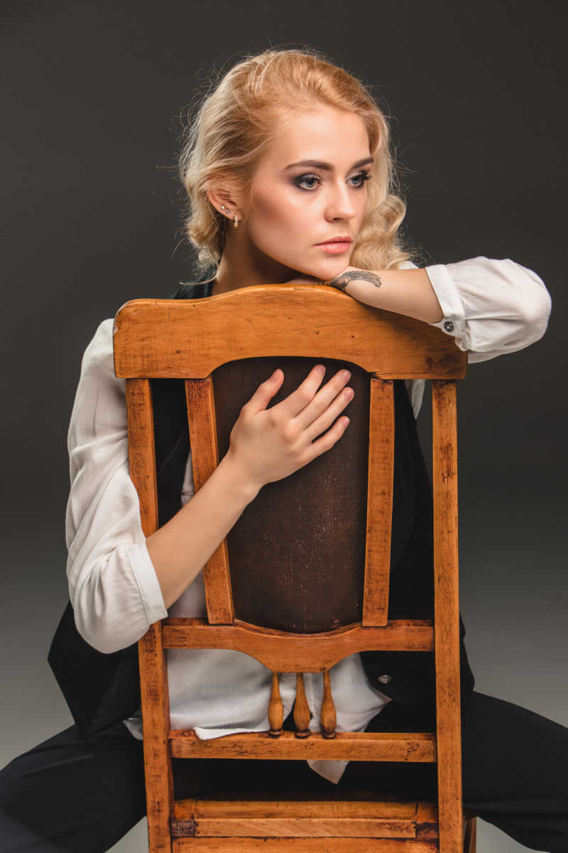 美丽模特反坐在木质椅子上