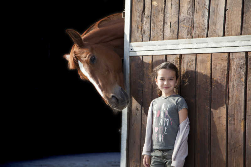 藏在木屋外面的小女孩和马