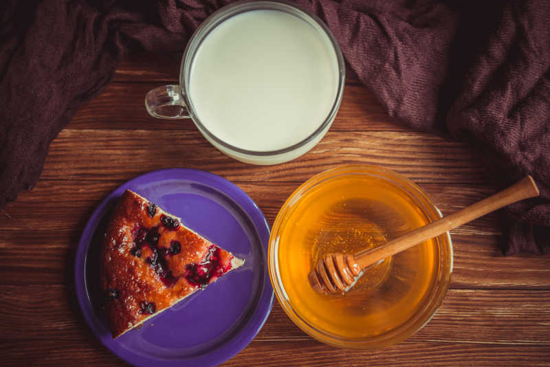 木桌上的水果蛋糕蜂蜜与牛奶