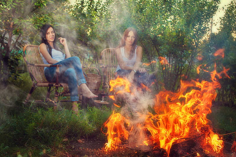 坐在火堆旁两个露营的美女