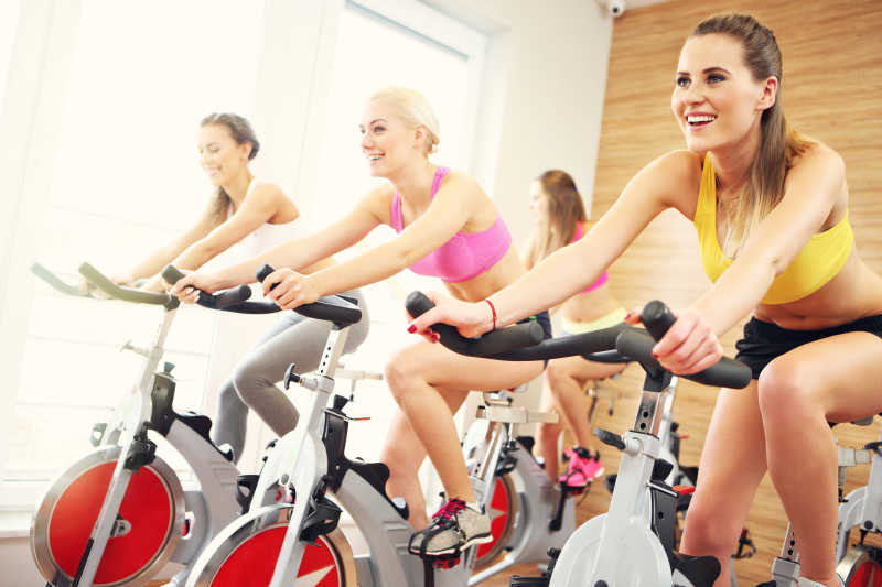 一群女子在健身房骑自行车