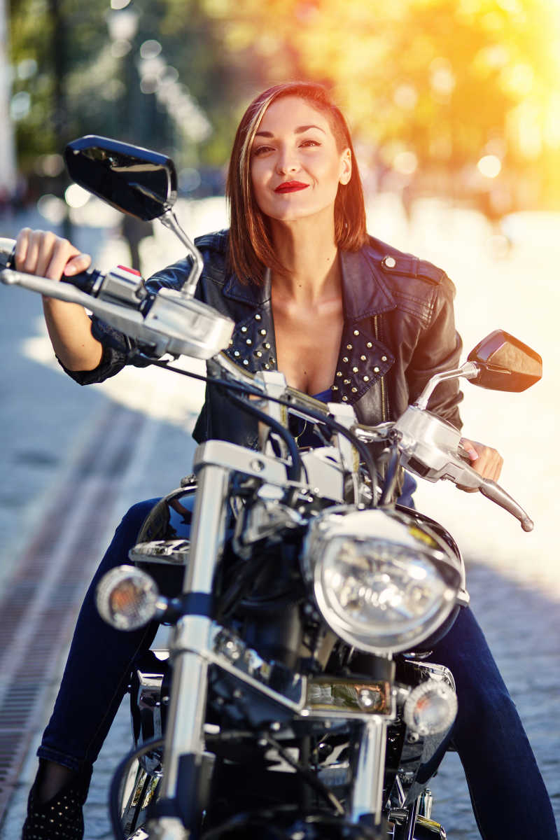 阳光下道路边上骑着摩托车上的性感女孩
