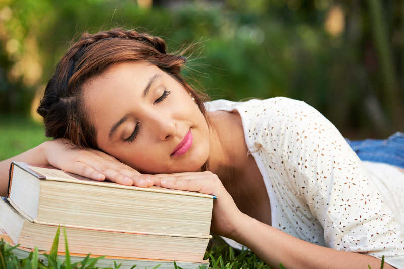 趴在书本上睡觉的女子