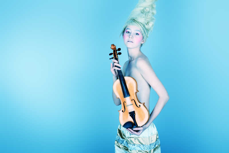 一个用小提琴摆姿势的年轻女子的艺术照