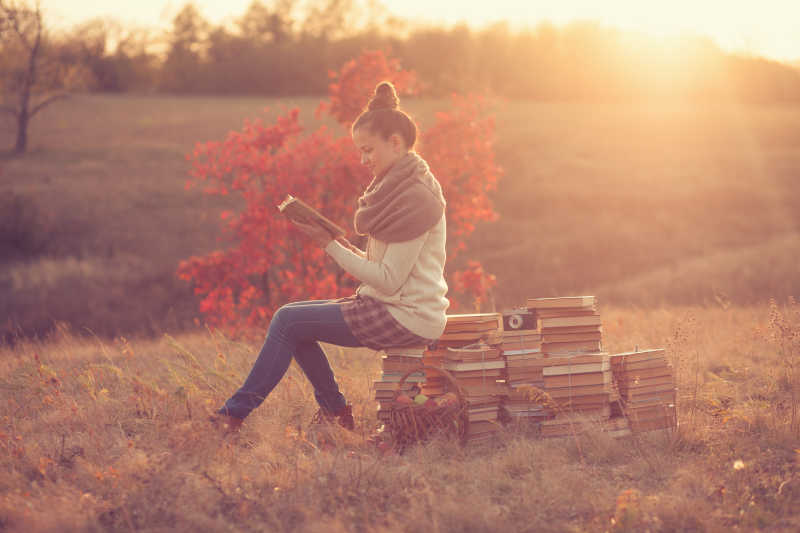 日落下在户外看书的女孩