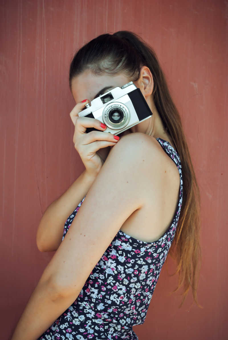 女孩用老式相机拍照