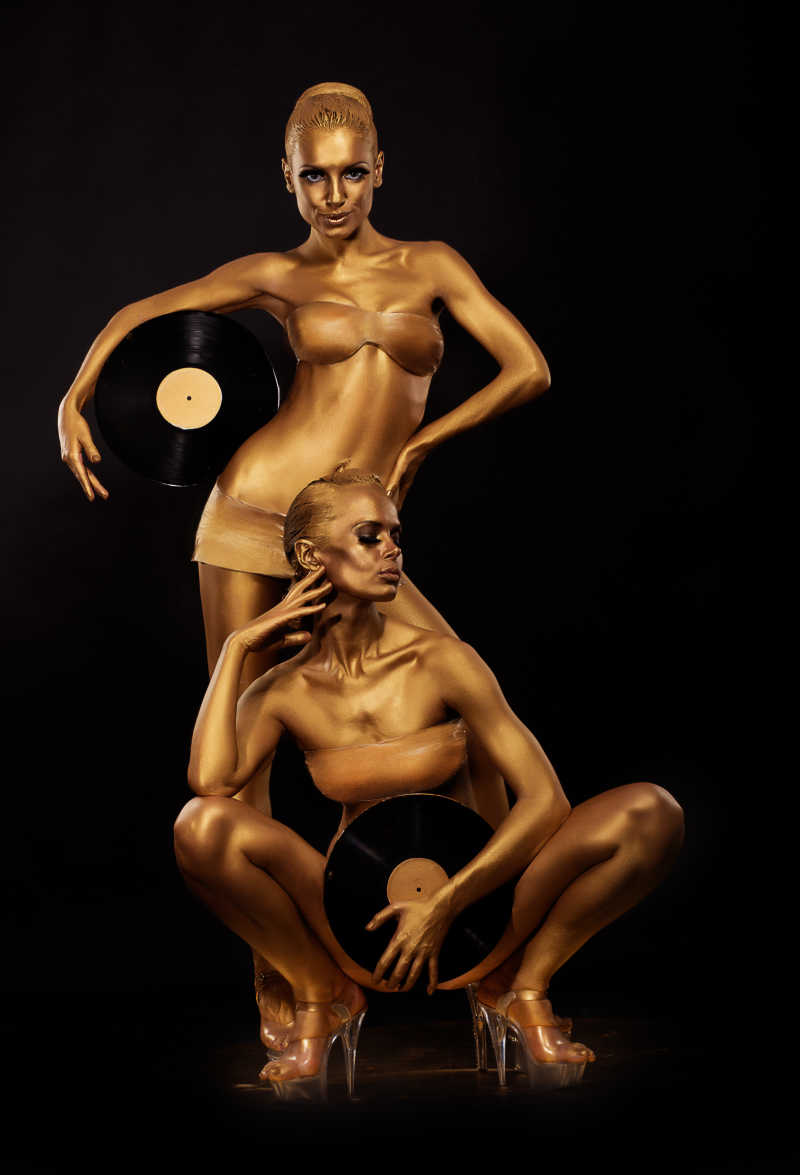 两个拿了黑胶唱片的涂满金色颜料的人体艺术
