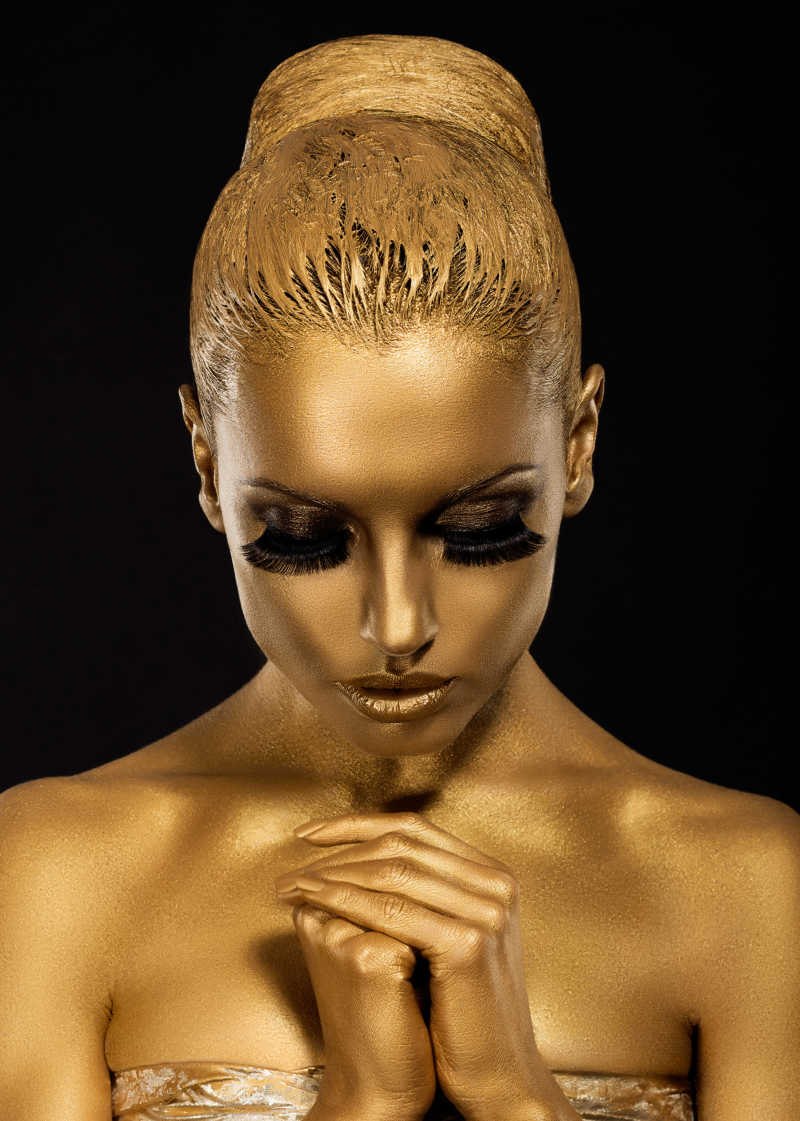 涂满金色颜料的做祈祷动作的人体艺术