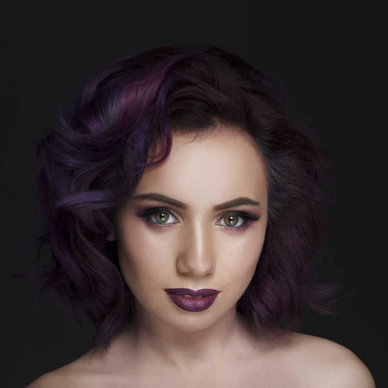 黑色背景下的紫色发型模特肖像