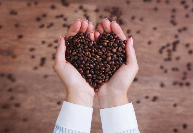 手里摆成心型的咖啡豆